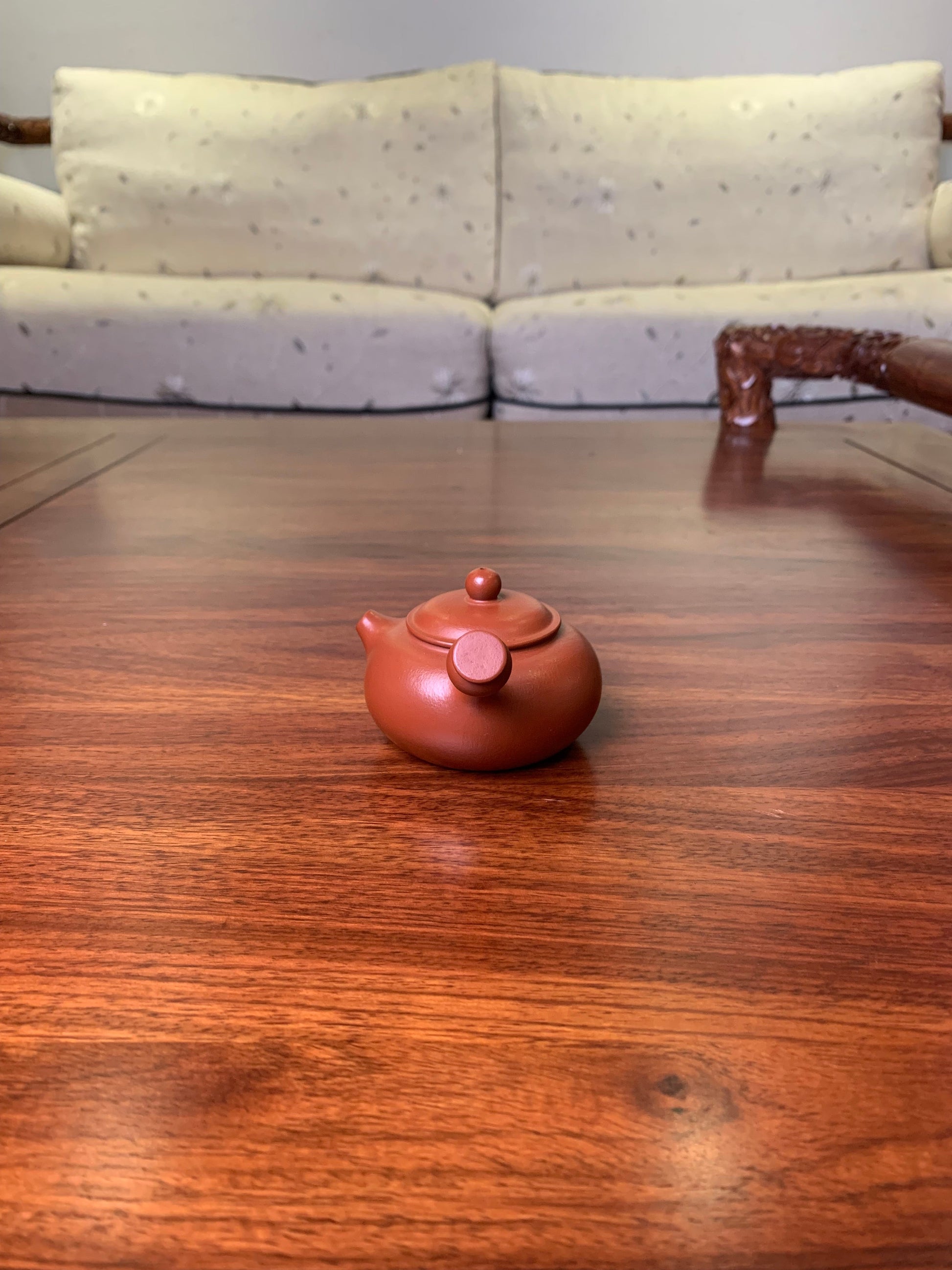 Small teapot on the table, handmade from purple clay handle