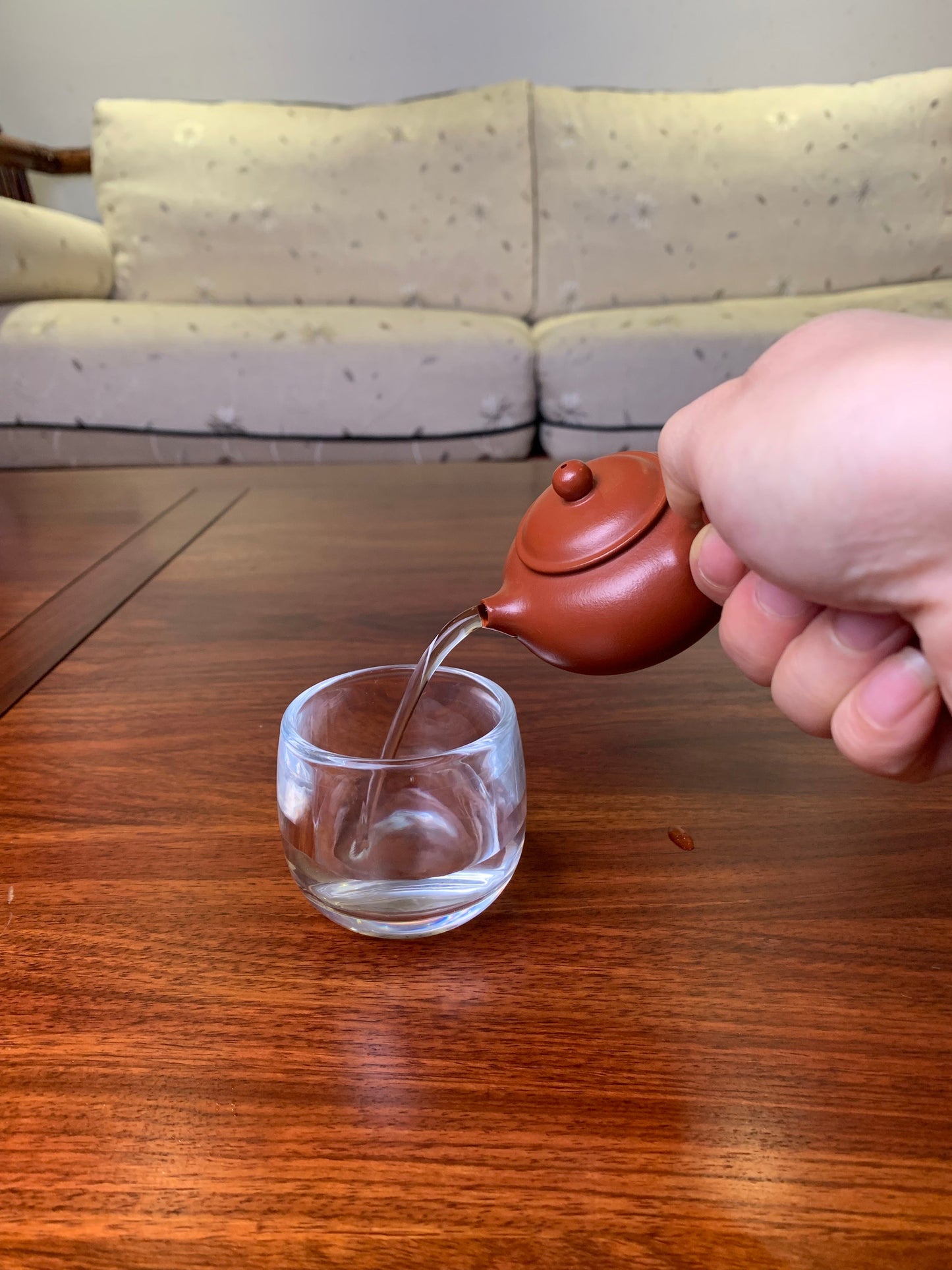 Small teapot on the table, handmade from purple clay pour