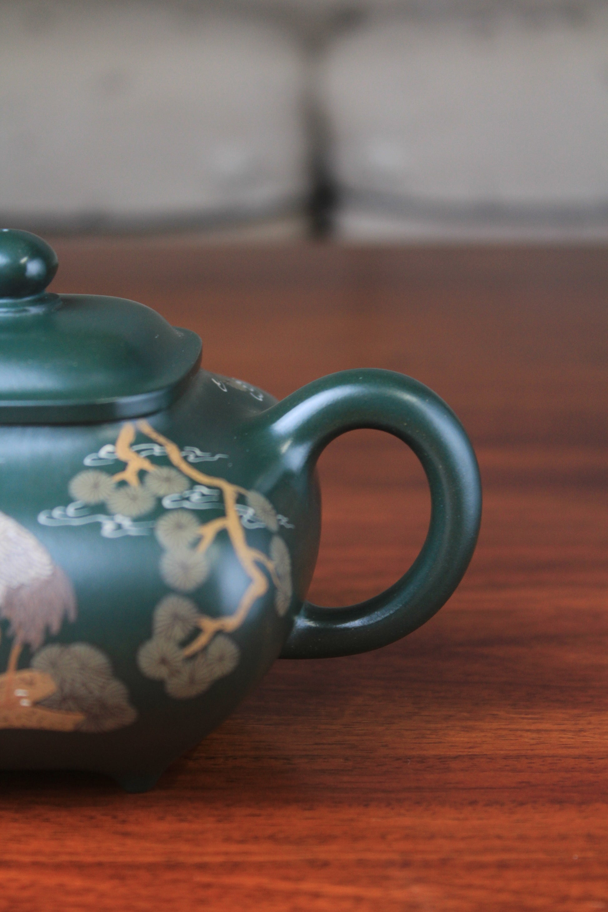 The handle of the Artistic teapot from teapot artist on the table