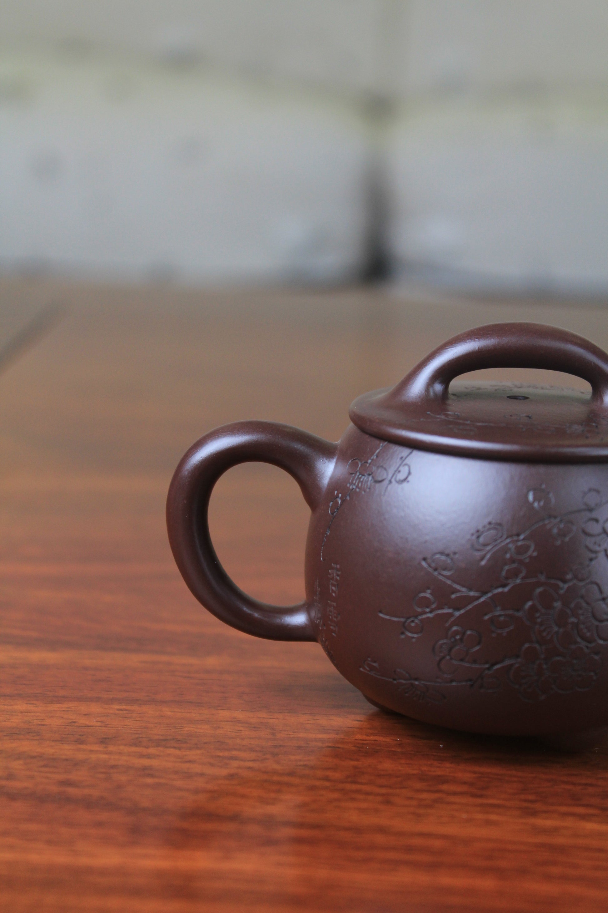 Handle of chinese teapot handmade with purple clay on the table