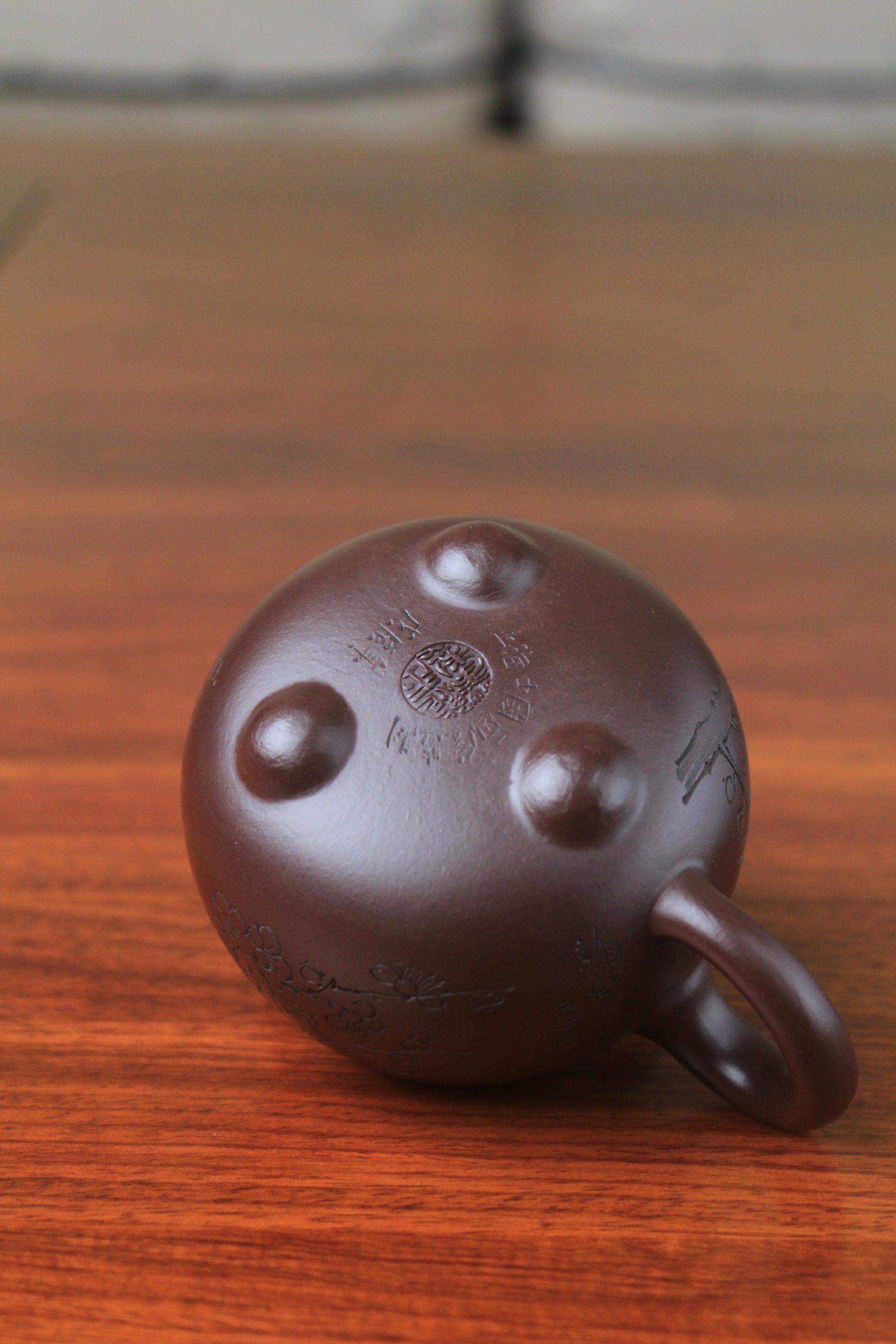 Bottom of cute chinese teapot handmade with purple clay on the table