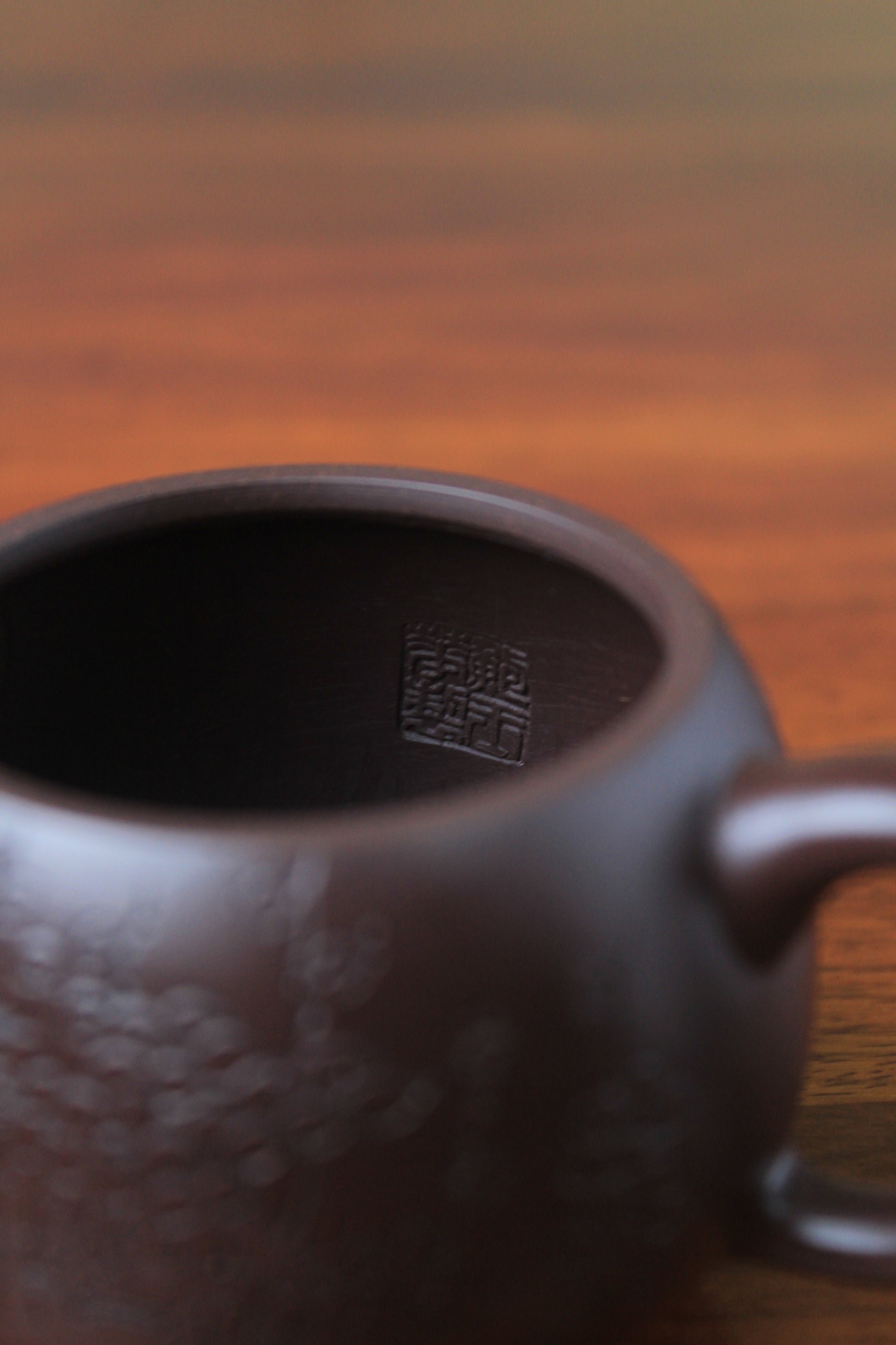 inside mark of the cute chinese teapot handmade with purple clay on the table