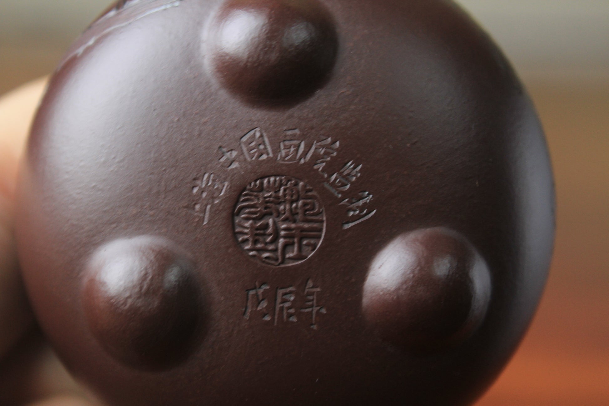 Bottom mark of the Cute chinese teapot handmade with purple clay on the table