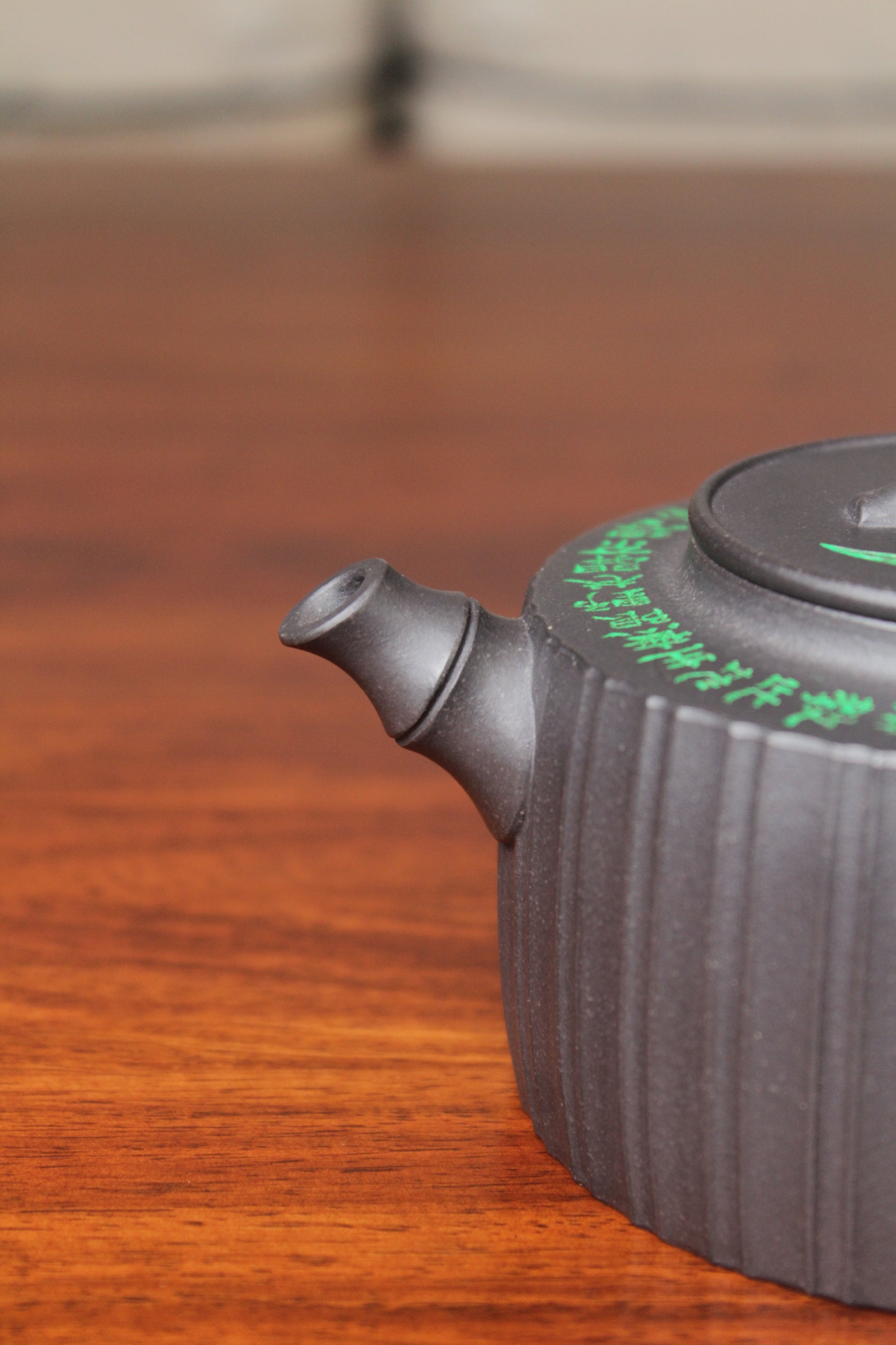 spout of the vintage teapot handmade with purple clay on the table