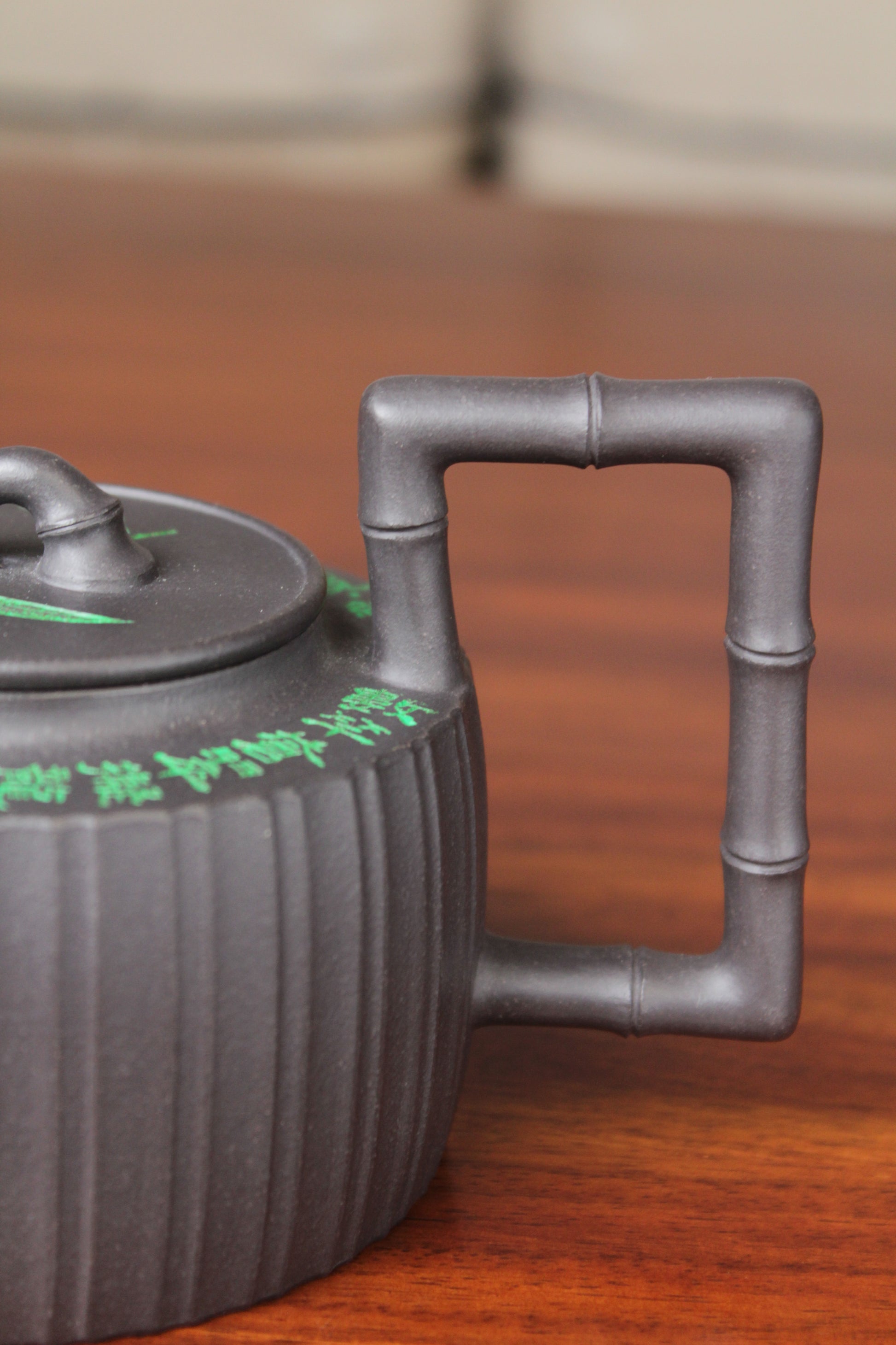 handle of the vintage teapot handmade with purple clay on the table