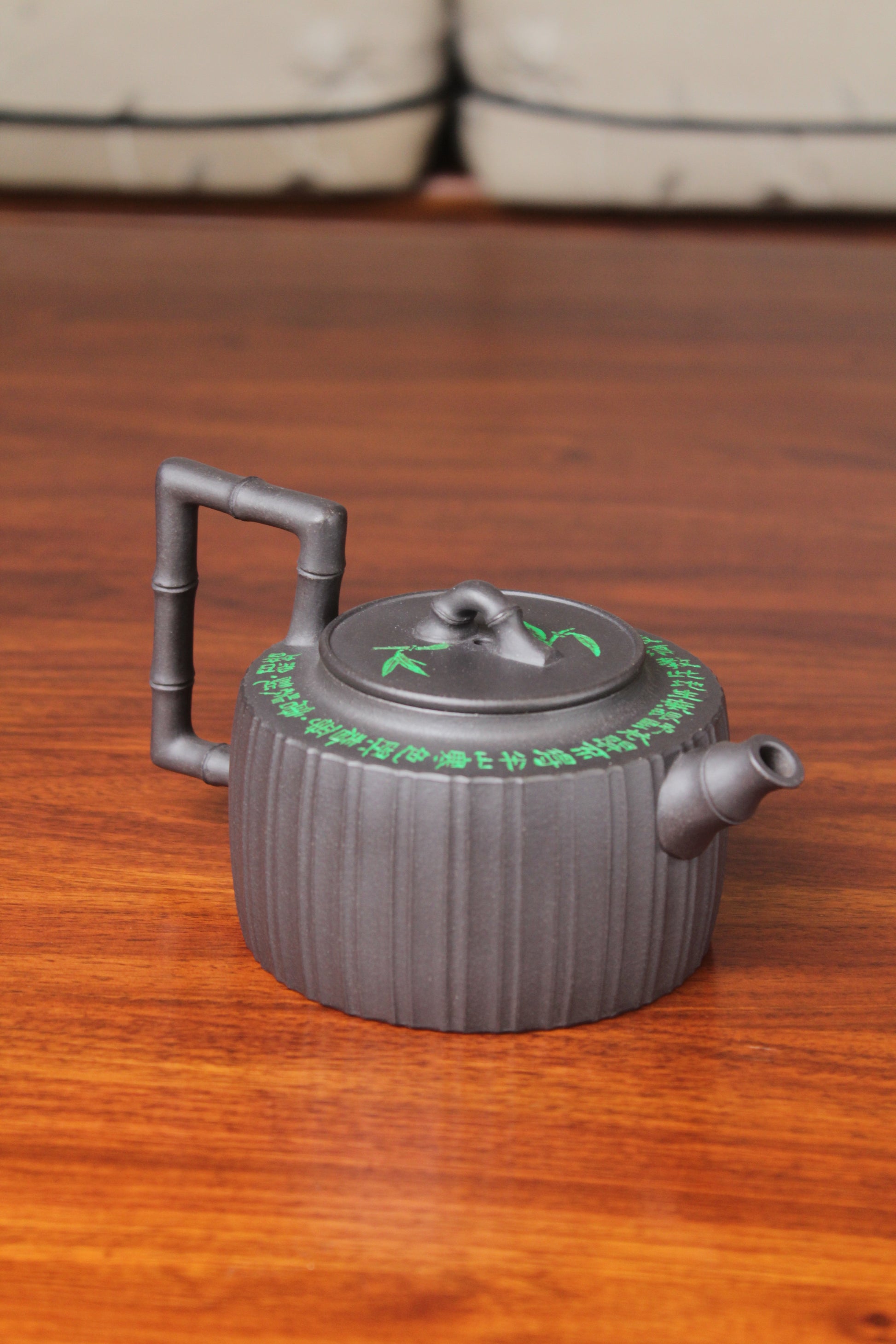 front detail of the vintage teapot handmade with purple clay on the table