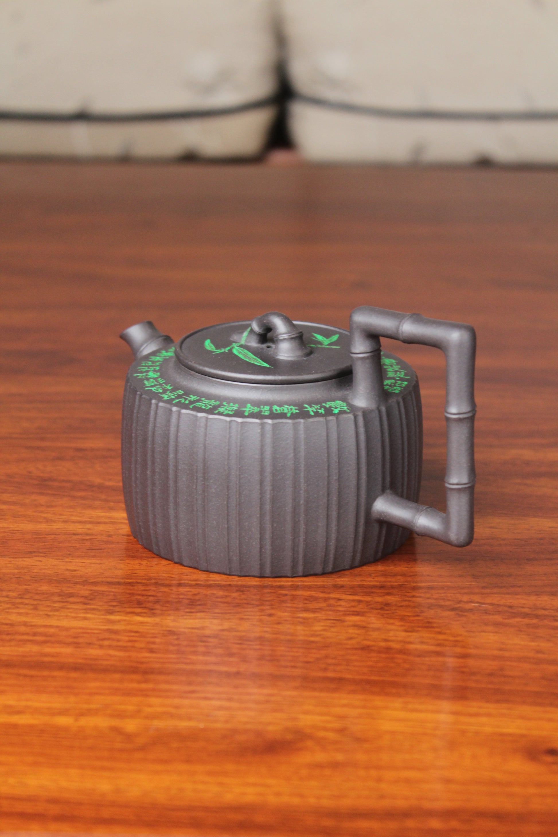 left of the vintage teapot handmade with purple clay on the table