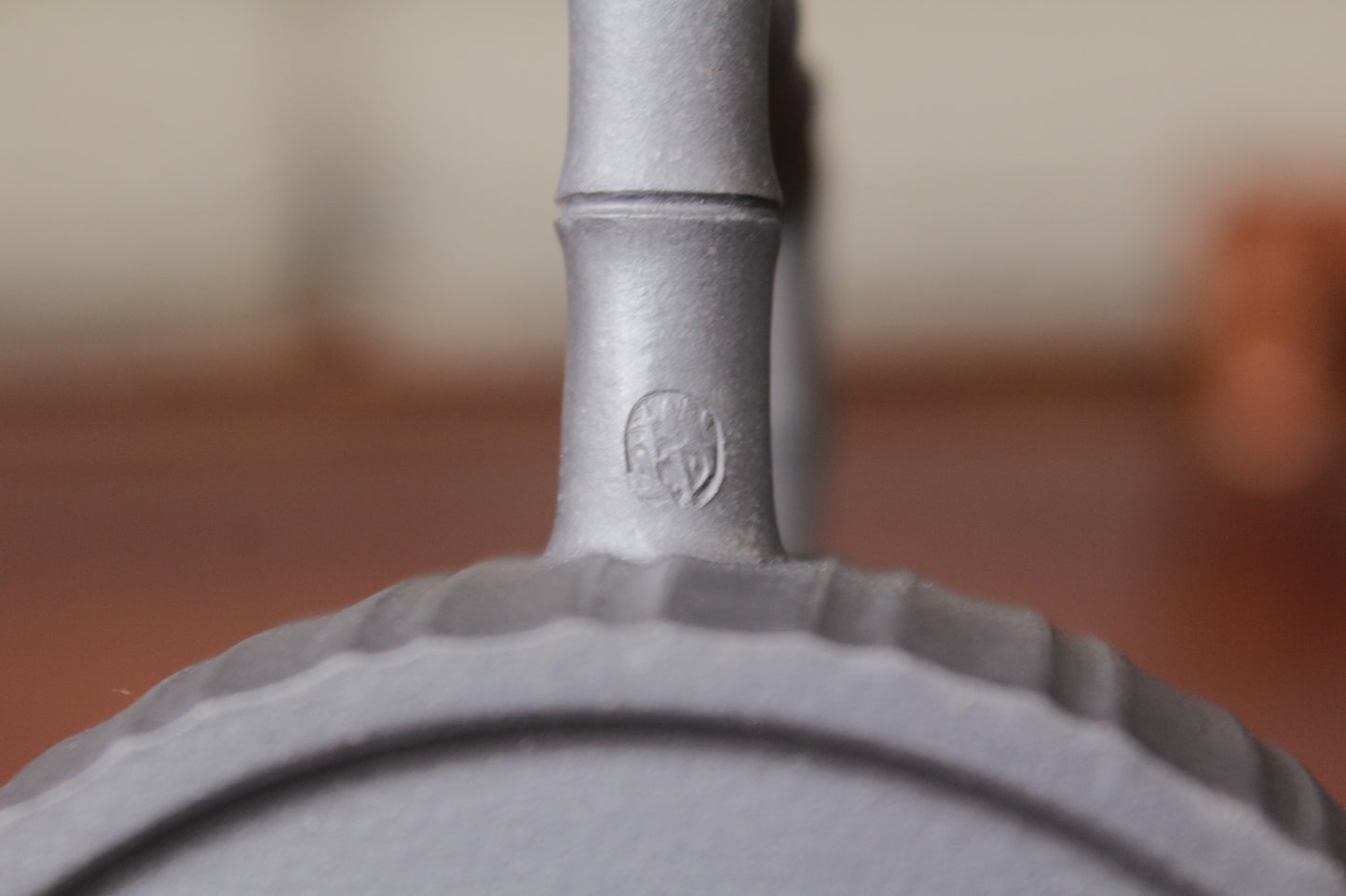 Handle mark of the vintage teapot handmade with purple clay on the table