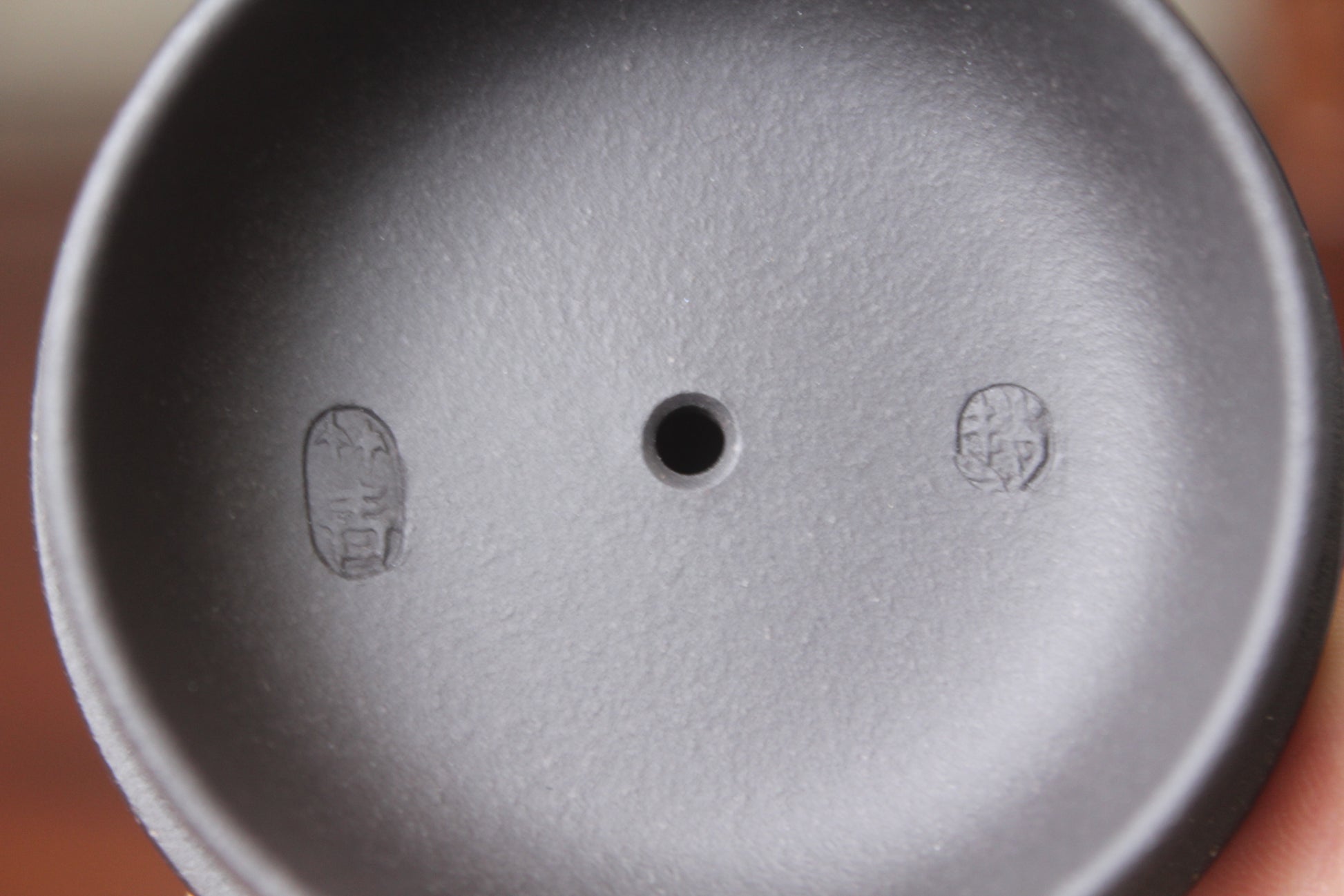 Lid mark of  the vintage teapot handmade with purple clay on the table