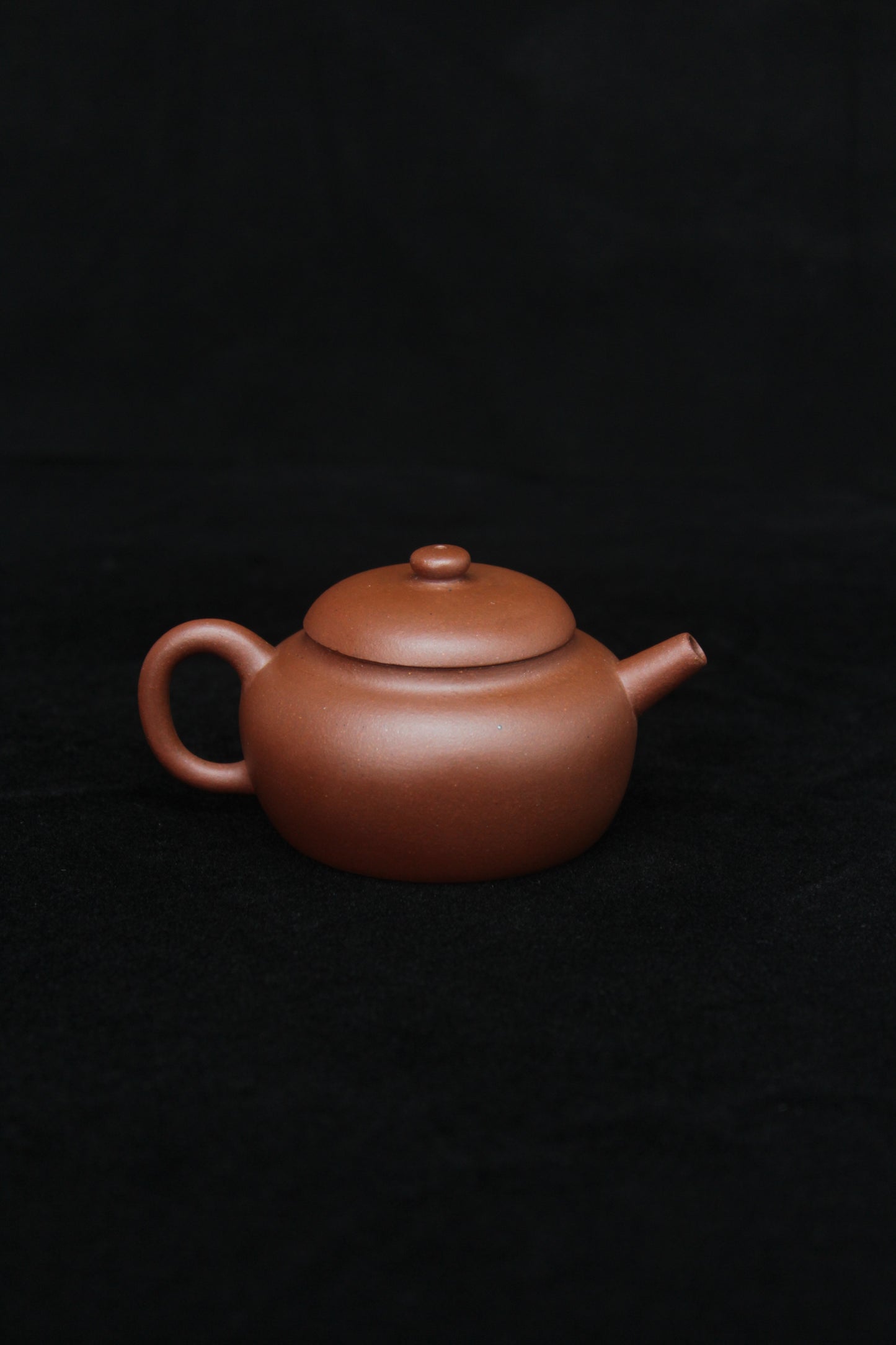 Back of a vintage small Yixing teapot made of dicaoqing purple clay