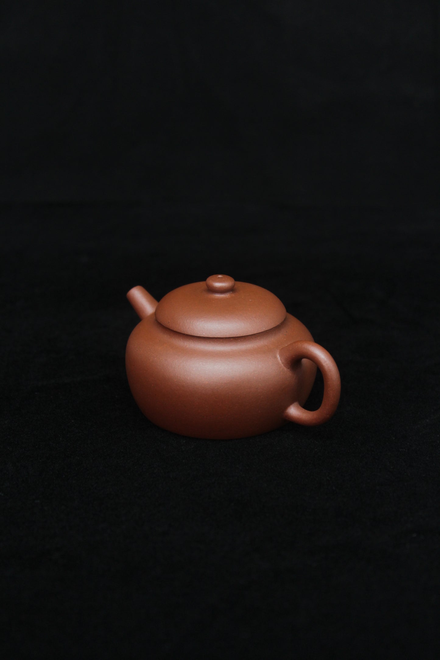 Right of a vintage small Yixing teapot made of dicaoqing purple clay