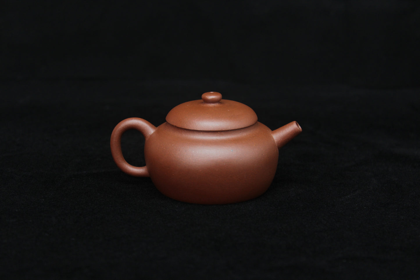 Back detail of a vintage small Yixing teapot made of dicaoqing purple clay