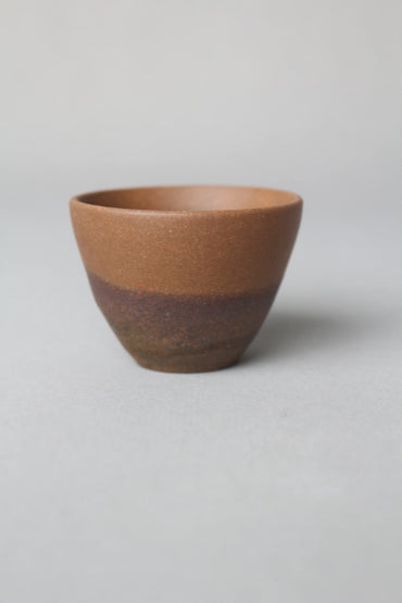 a beautiful zisha teacup is on the table side view