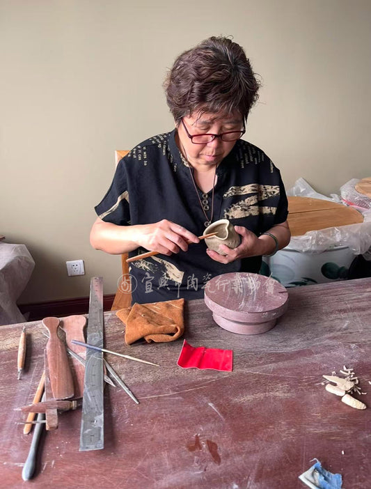 yixing teapot artist mei baoyu is making a teapot