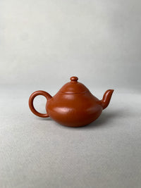 back view of authentic yixing teapot named li xing on the table