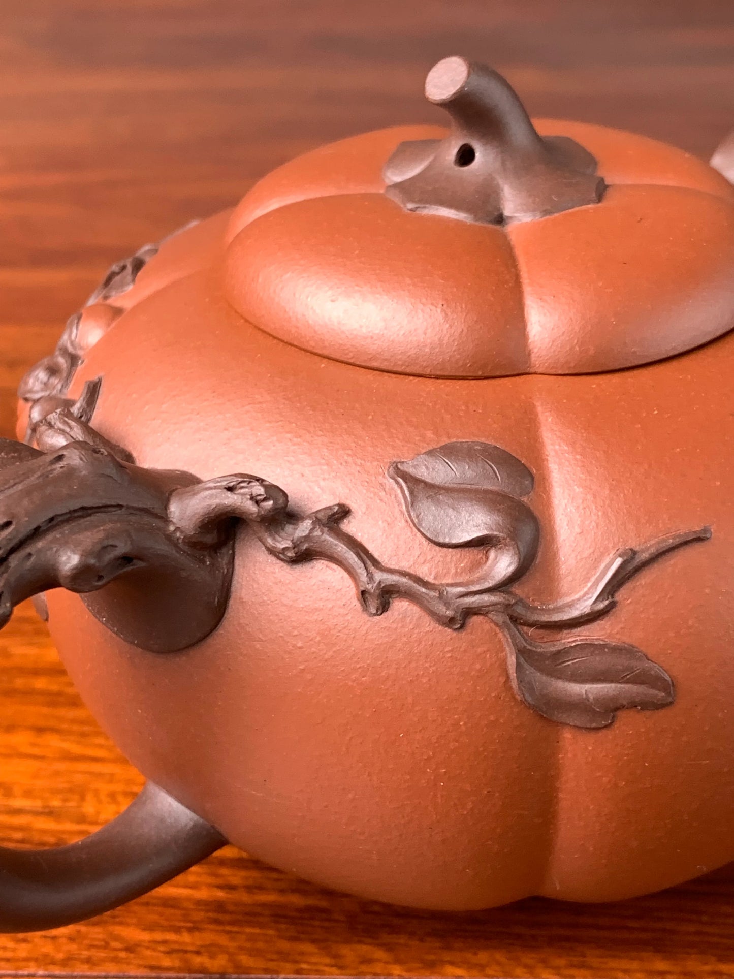 Close up photo of pumpkin vine-like decoration on teapot