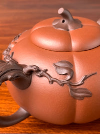 Close up photo of pumpkin vine-like decoration on teapot