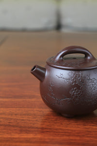Spout of chinese teapot handmade with purple clay on the table