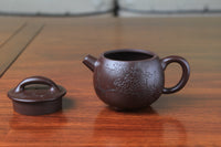 detail of this cute chinese teapot handmade with purple clay on the table