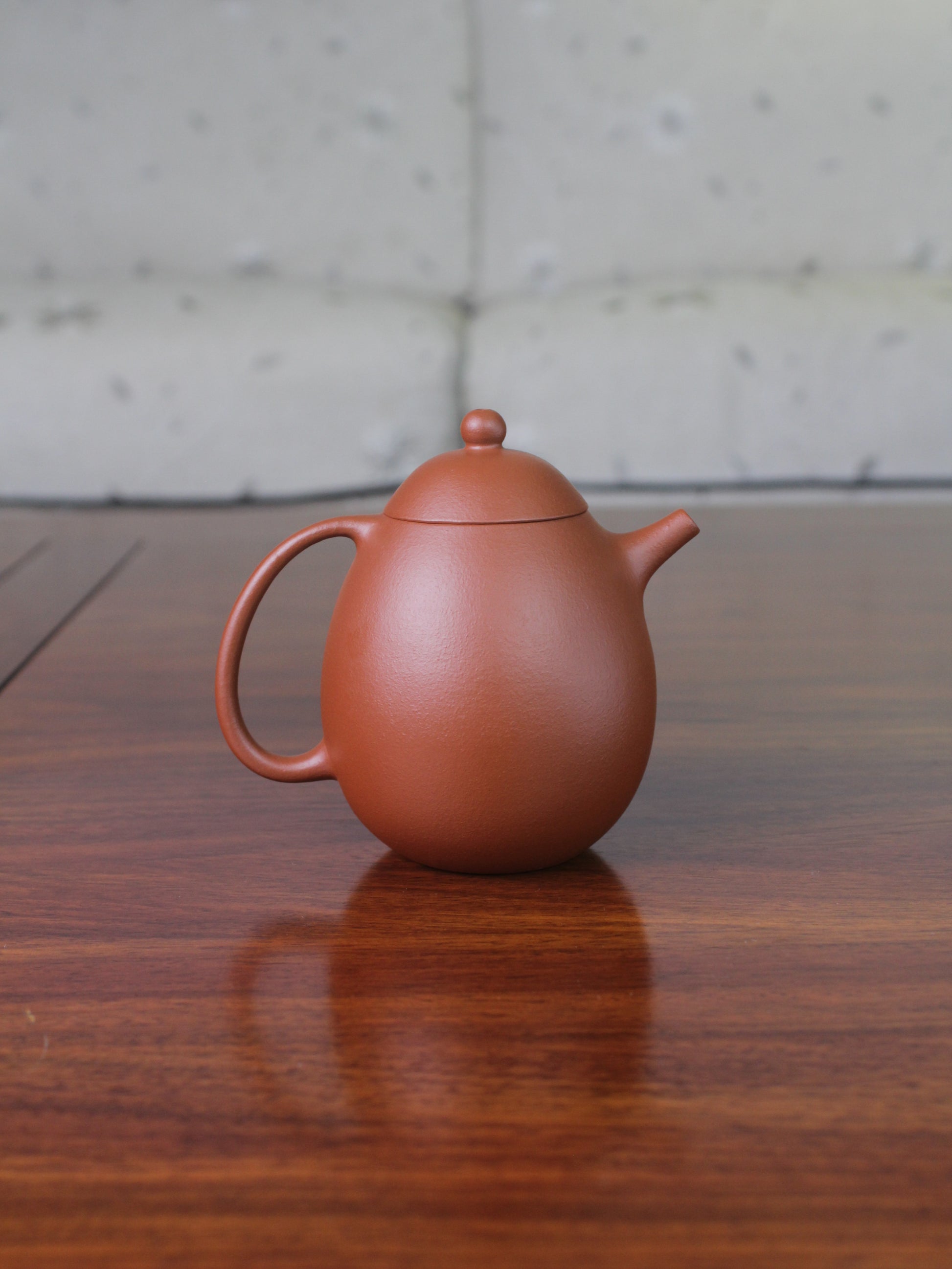Back view of the Chinese teapot on the table. This yixing clay teapot was handmade with authentic purple clay zhu ni.