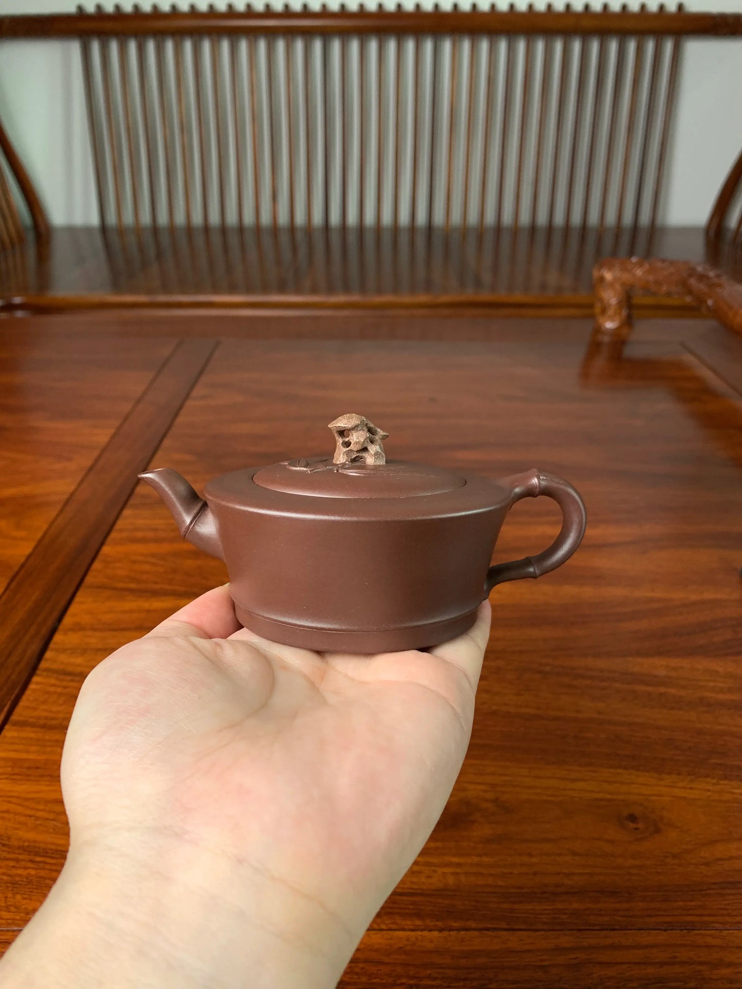 Holding the teapot in hand, we can observe the intricate details on its front