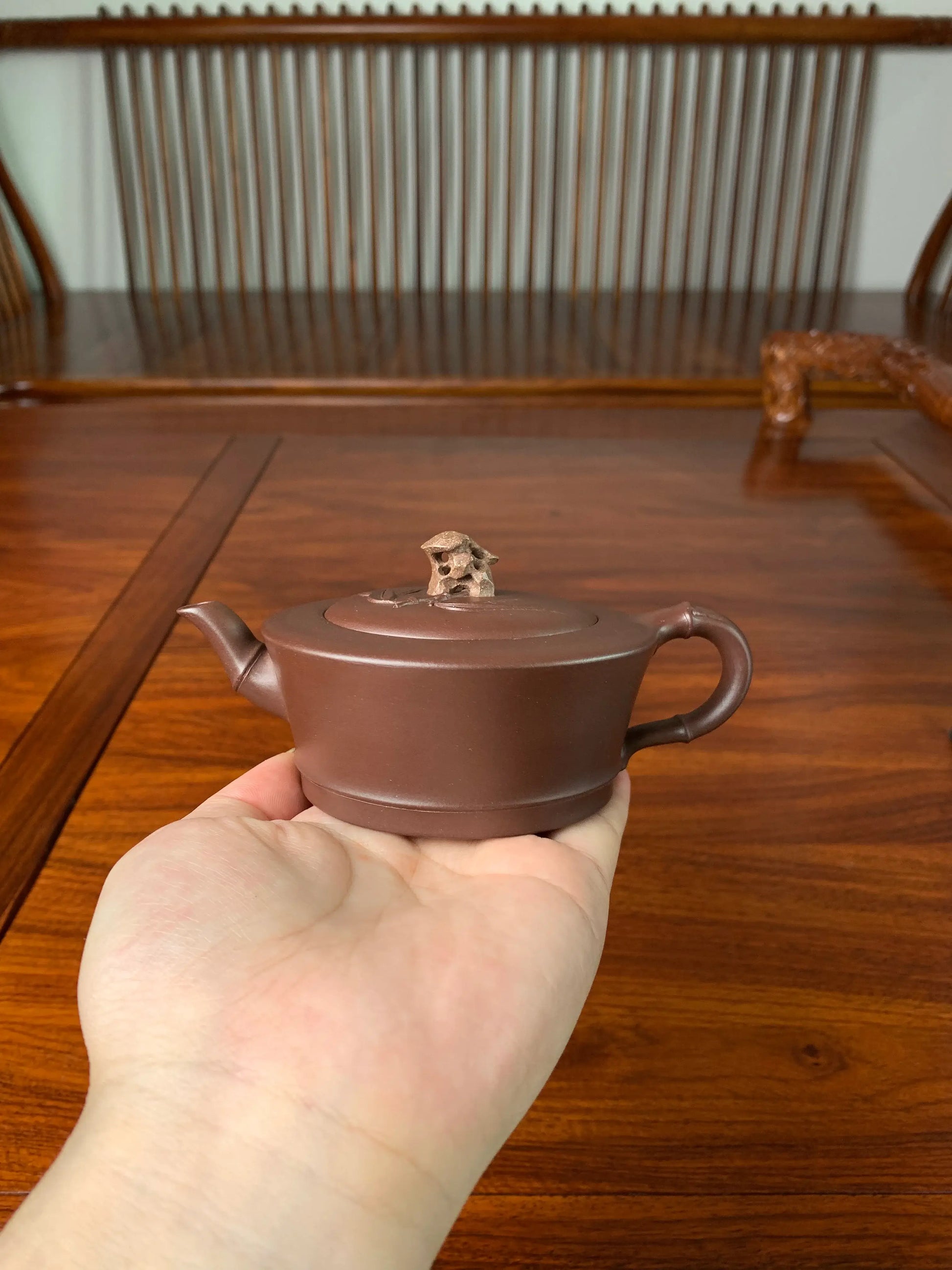 Holding the teapot in hand, we can observe the intricate details on its front