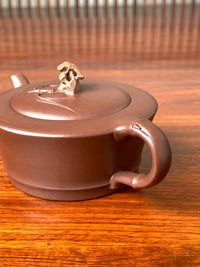 Side-back view of the collectible teapot handle's decorative details