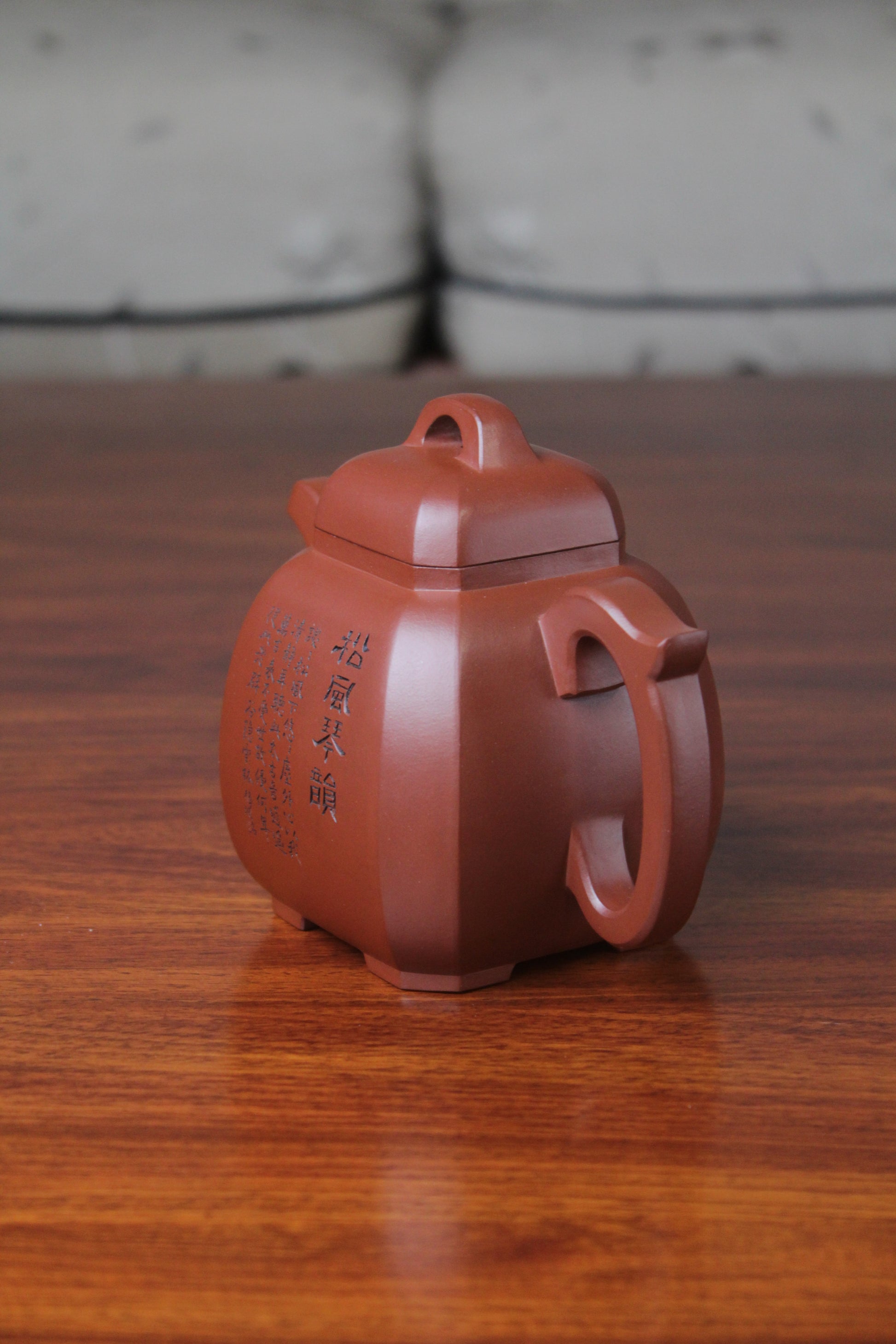 left of the collectible teapot from teapot artist on the table