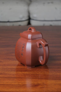 left of the collectible teapot from teapot artist on the table