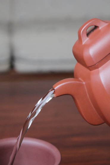 pour of collectible teapot from teapot artist on the table