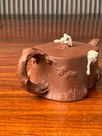 A closer look at the decorative details on the handle of the collectible teapot