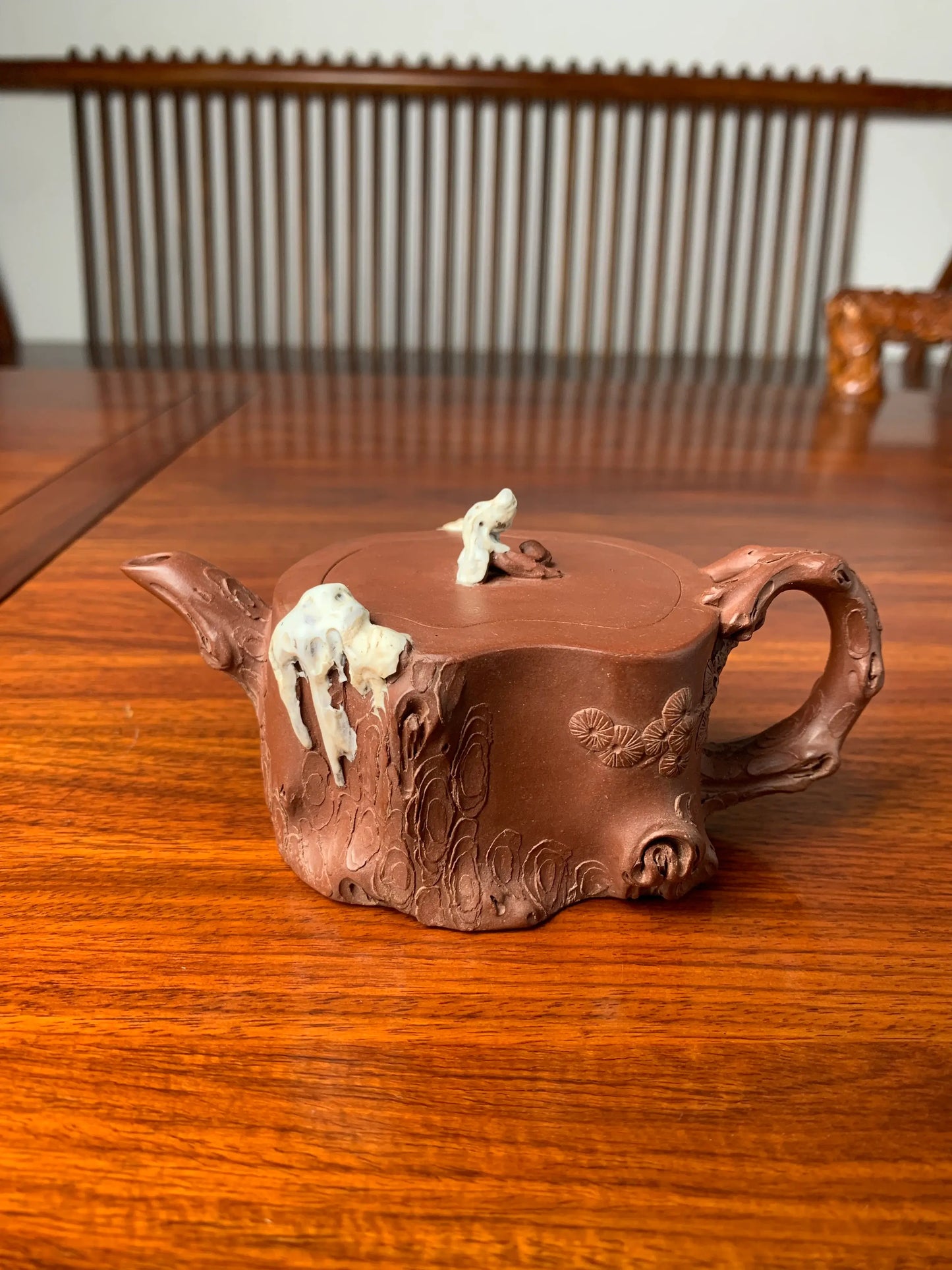 A close up front view of the decorative details on the collectible teapot