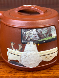 Detail of the cat in the design on the teapot.