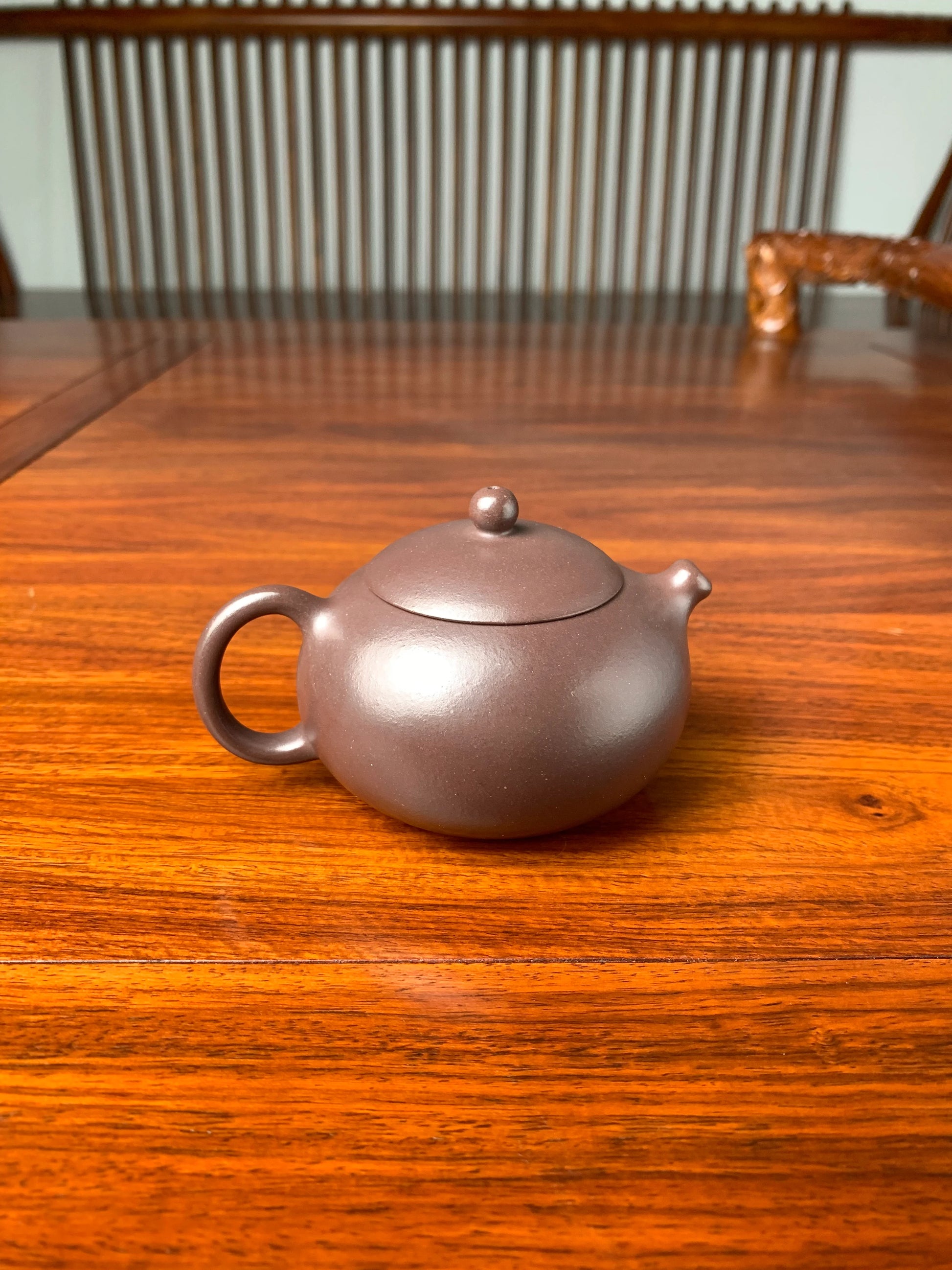 the back view of handmade yixing teapot named xi shi on the table