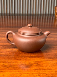 the back view of the handmade yixing teapot named yong fu lian zi