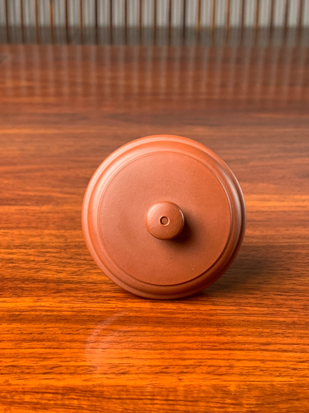 Front view of the lid of a collectible teapot with a minimalist design style