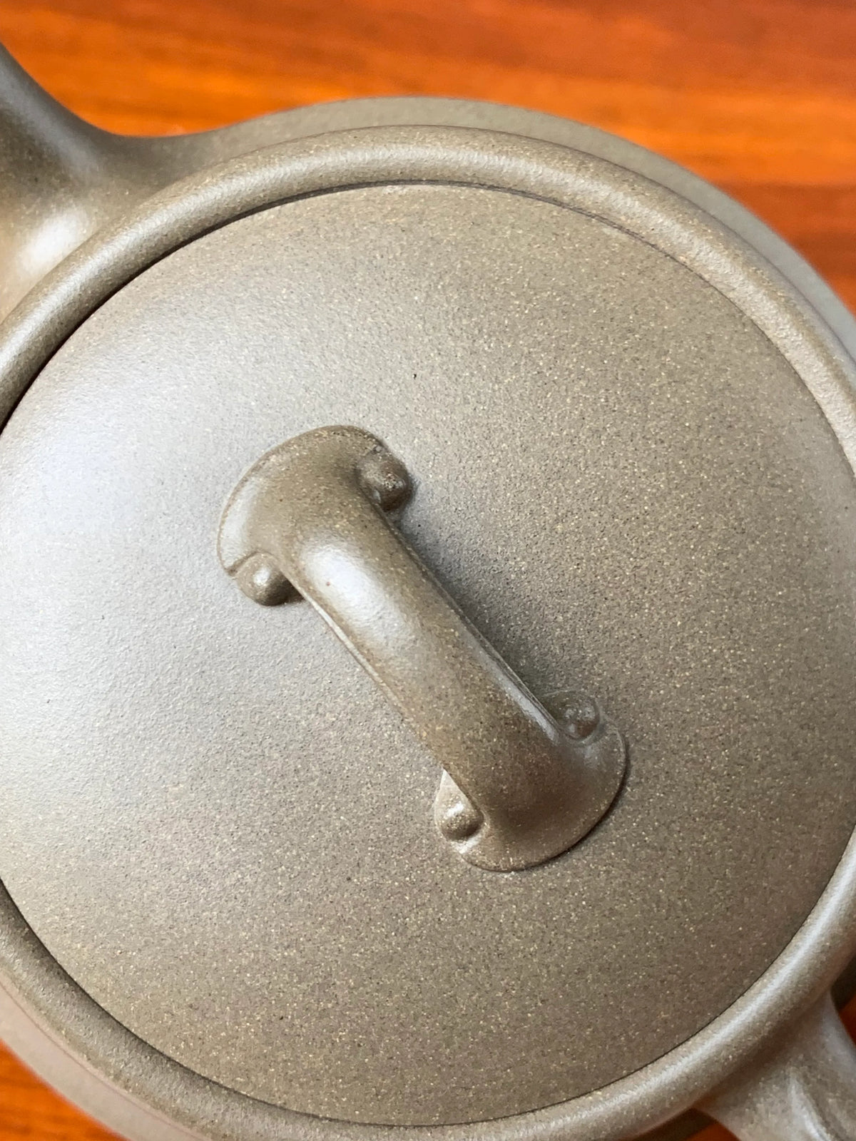 Viewed from above, the lid knob and lid of a finely crafted teapot.
