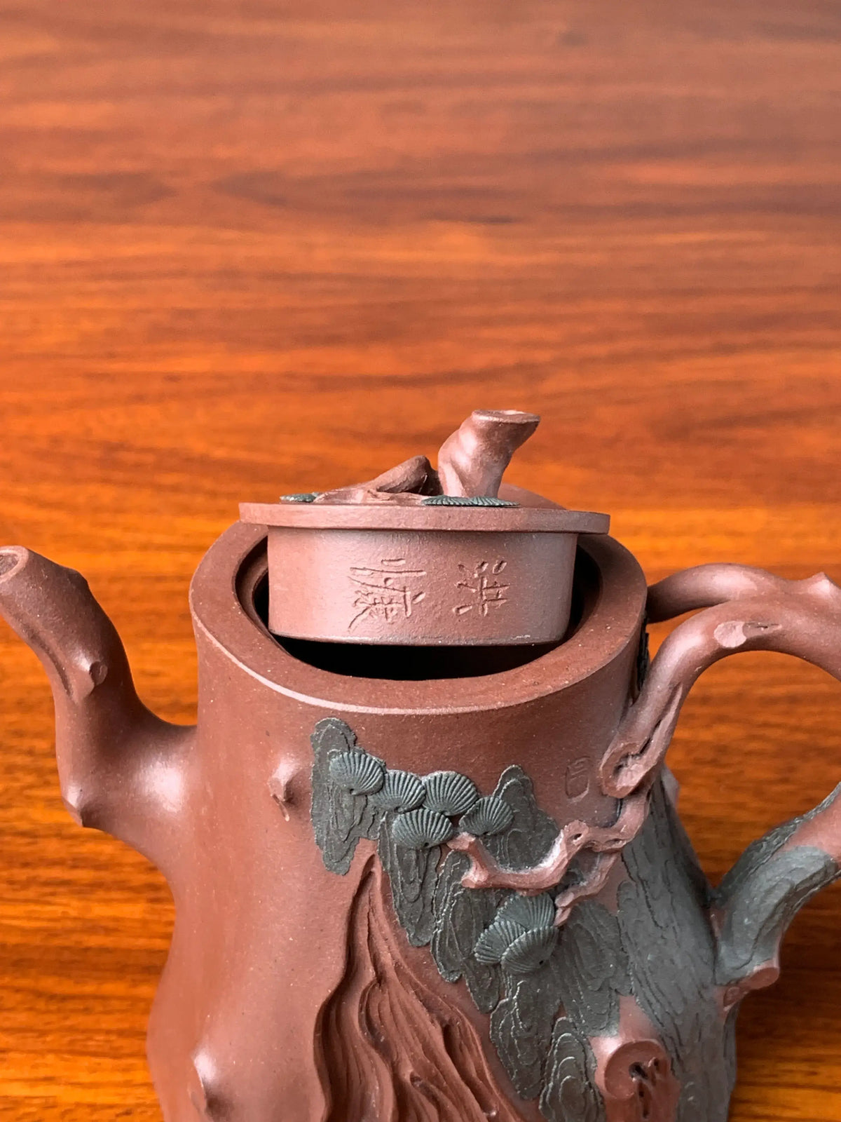 The teapot lid bears the signature of the artist Hong Kang