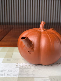 spout details of the collectible teapot named pumpkin on the table