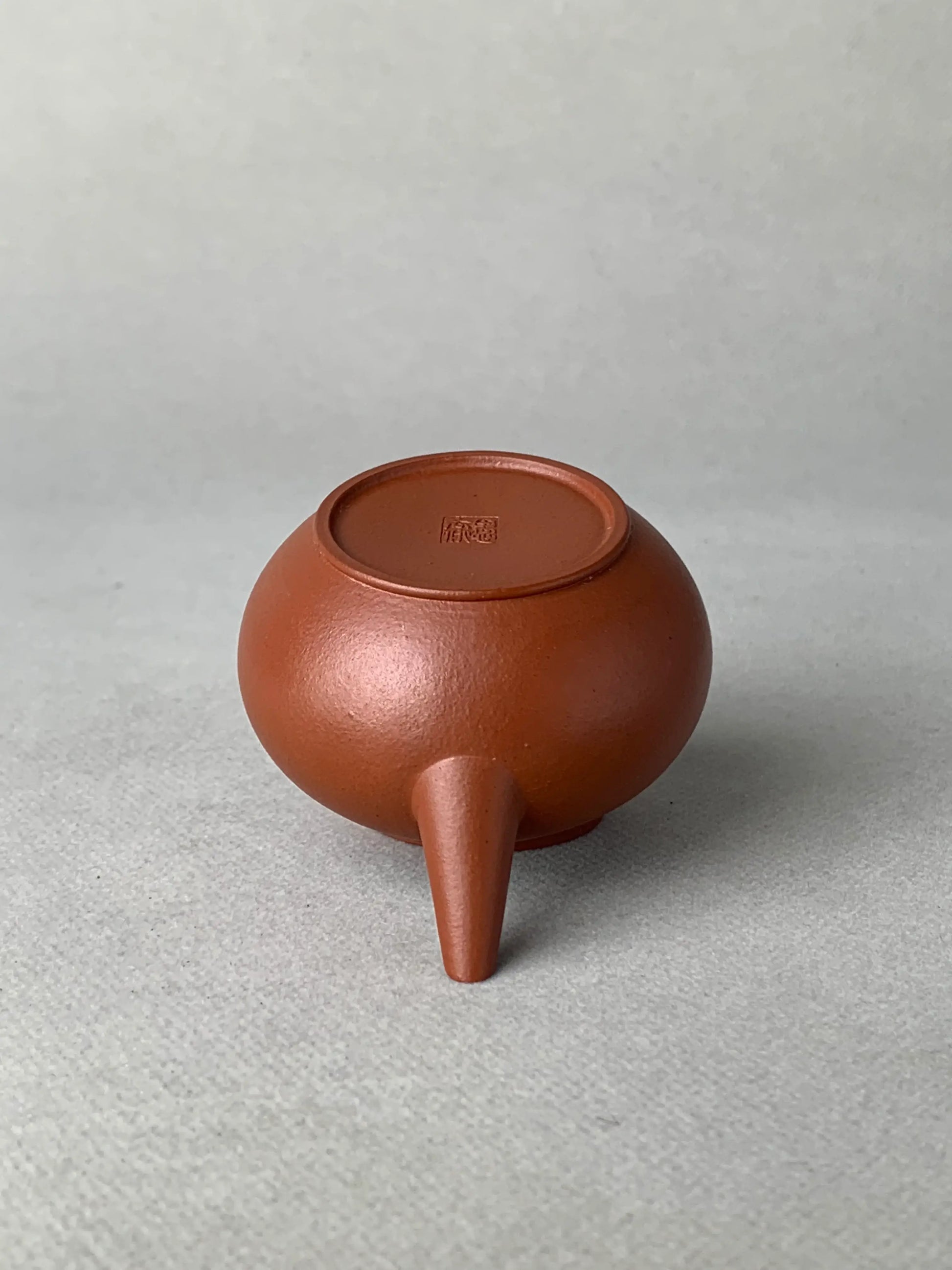 The body of the teapot is placed upside down on the table to see the bottom details