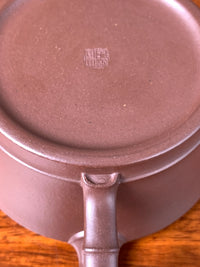 With the teapot turned upside down, the intricate details of the handle are revealed in close-up