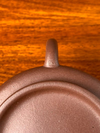 The teapot has the seal of art master Qian Xiaojun on the end of the handle.