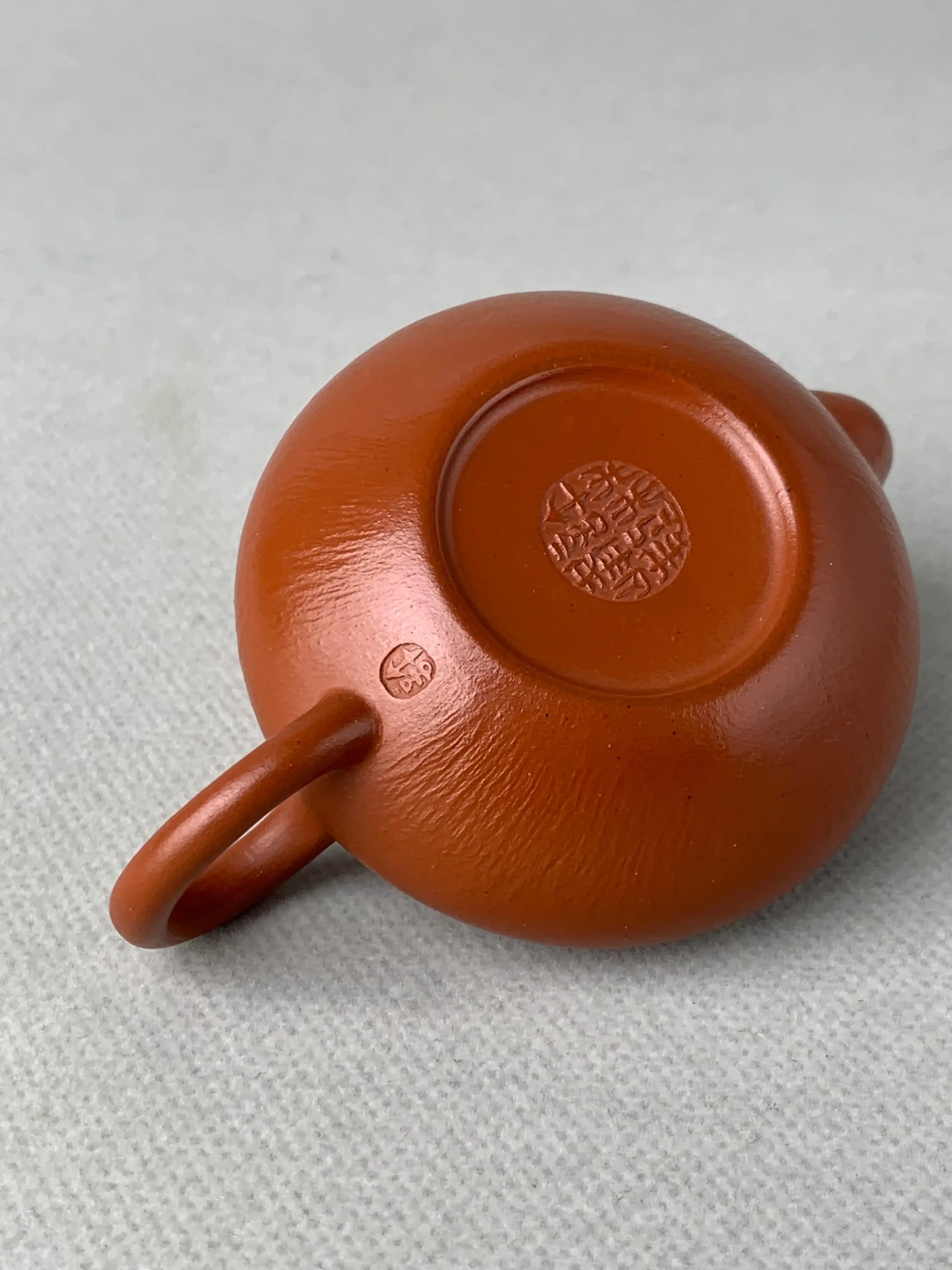 Details of the seals on the bottom of the teapot and the underside of the handle