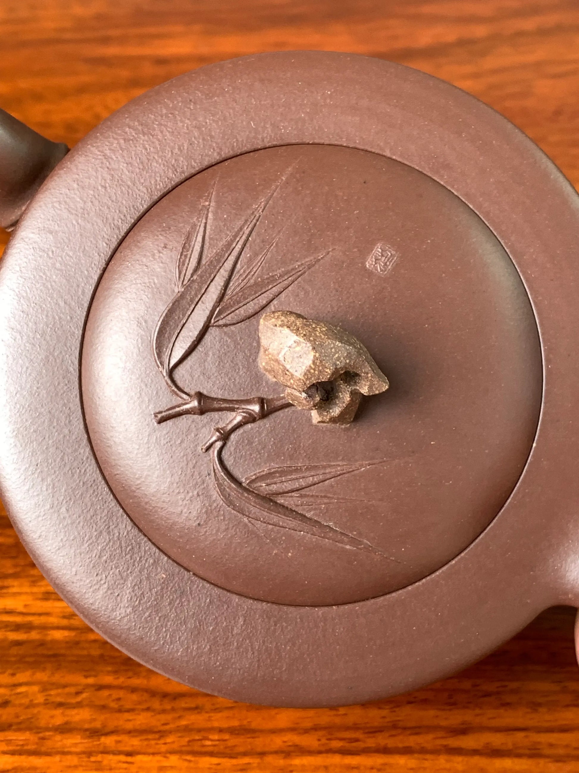 Fine details of the hand-applied clay bamboo branches and leaves decorating the teapot lid