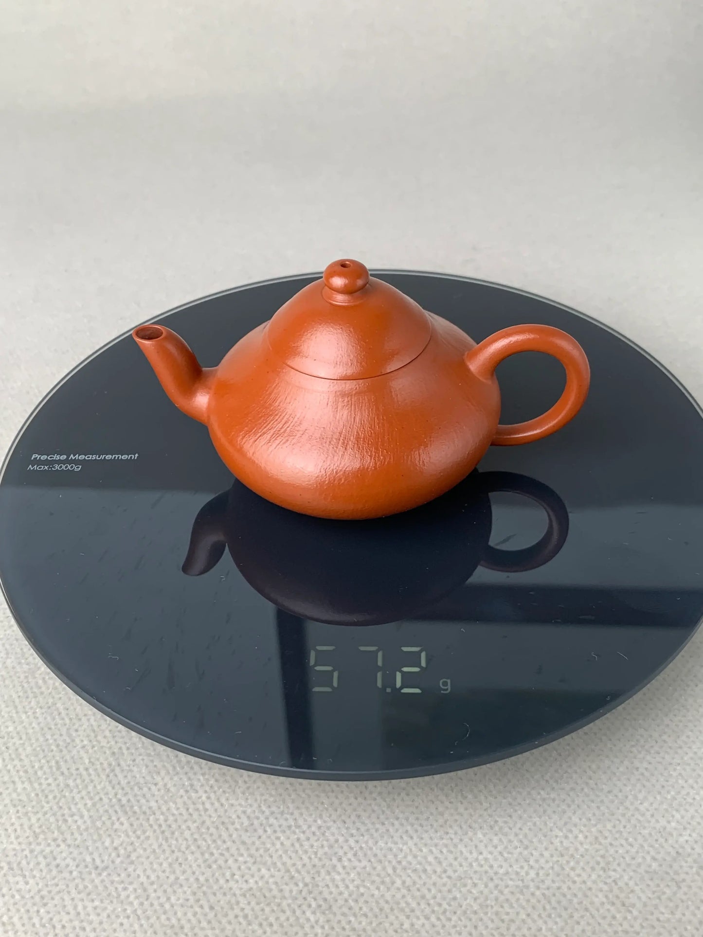 the weight of the teapot is 57.2 g