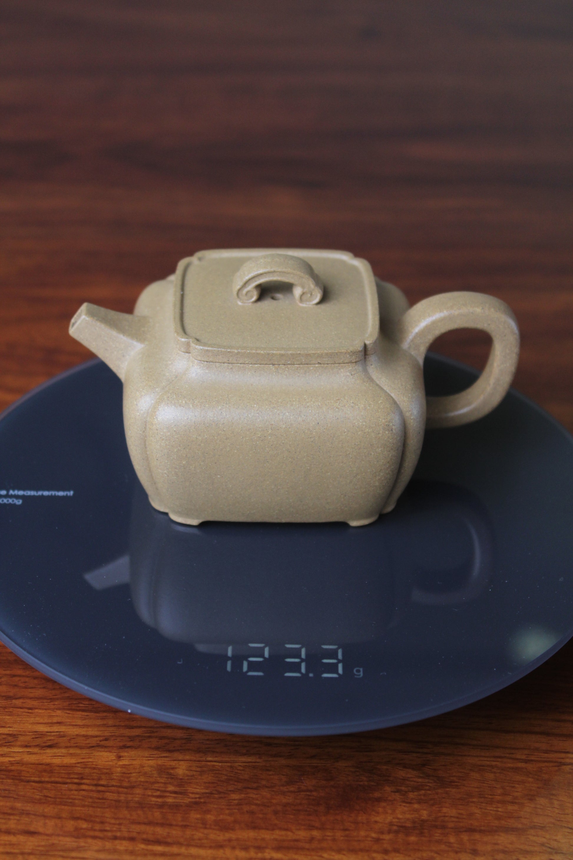 weight of the yi xing tea pot handmade with purple clay on the table