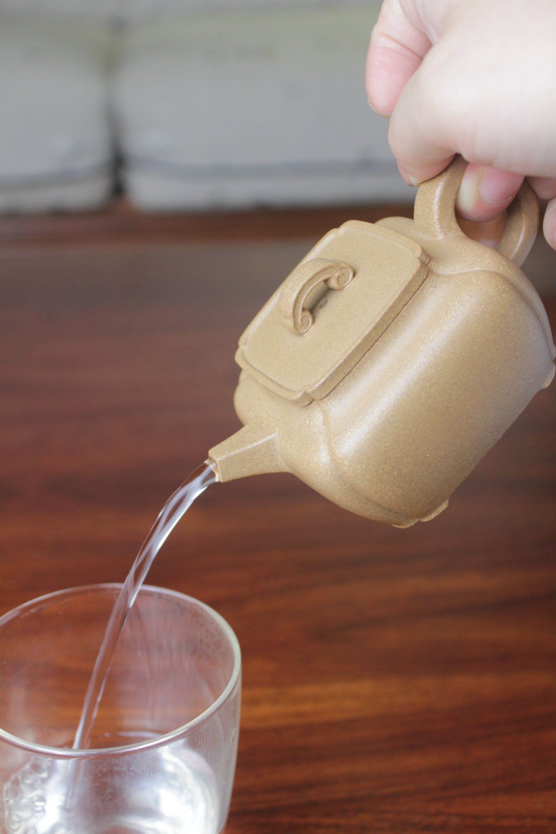 Pour of the yi xing tea pot, handmade with purple clay on the table