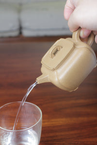 Pour of the yi xing tea pot, handmade with purple clay on the table