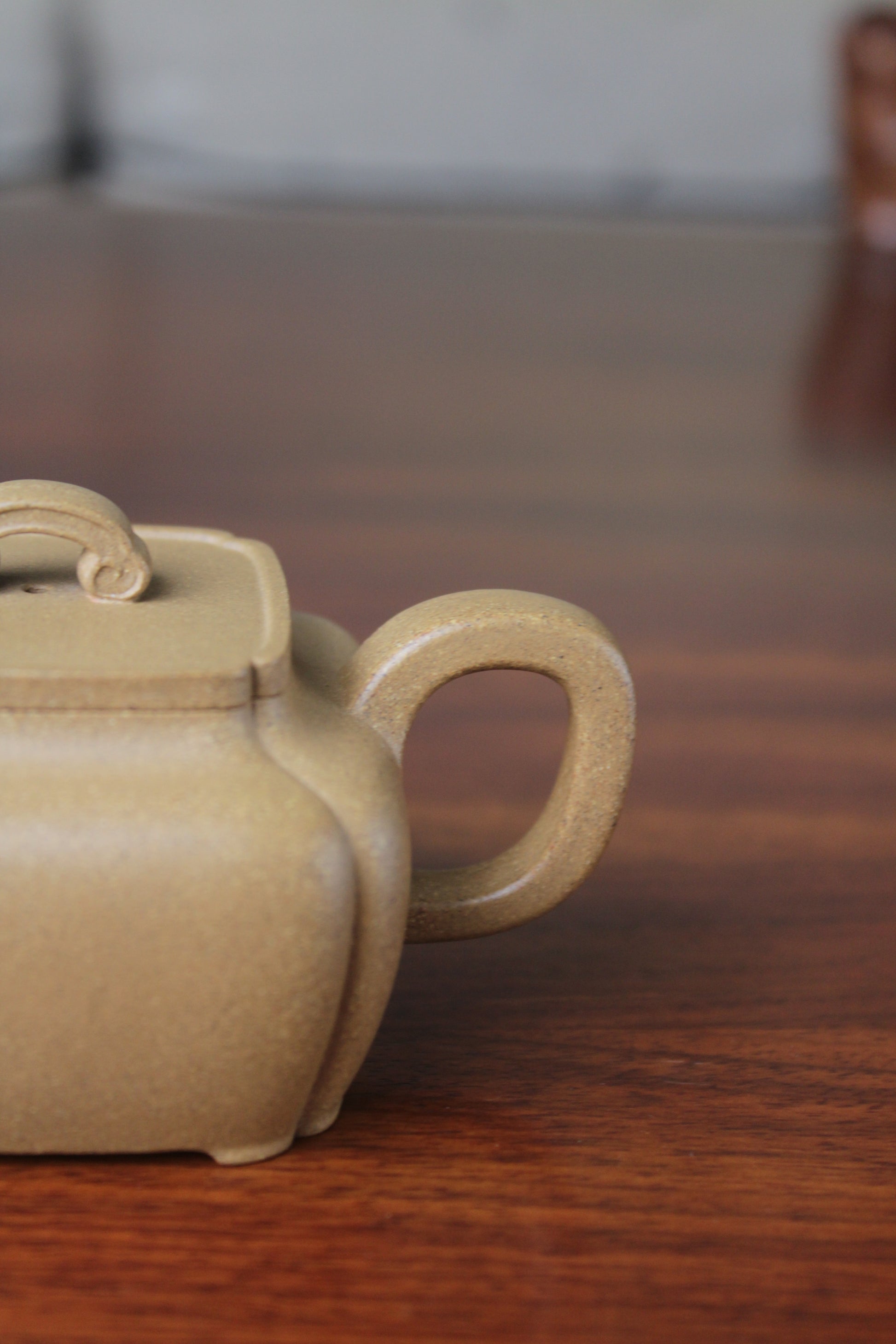 Handle of the yi xing tea pot handmade with purple clay on the table