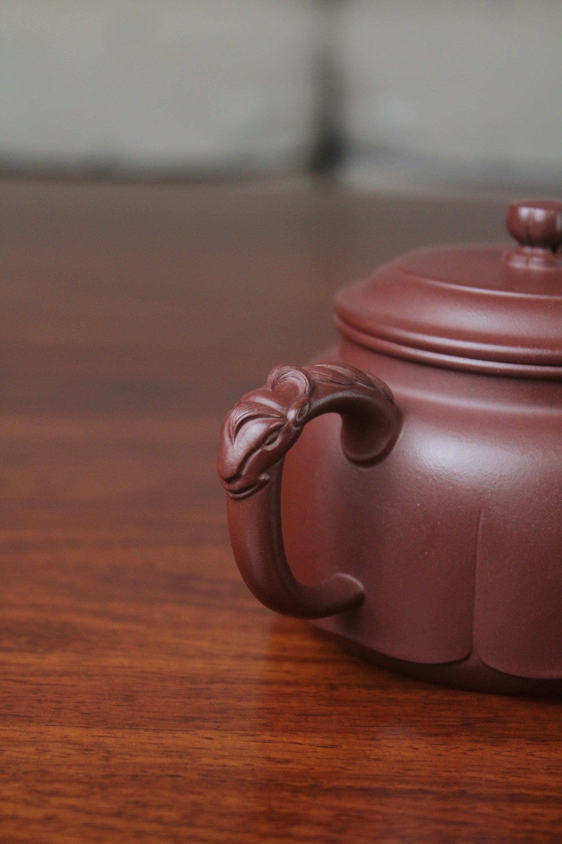The handle of the yixing clay teapot on the table